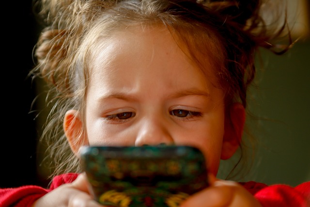une enfant qui joue sur un smartphone
